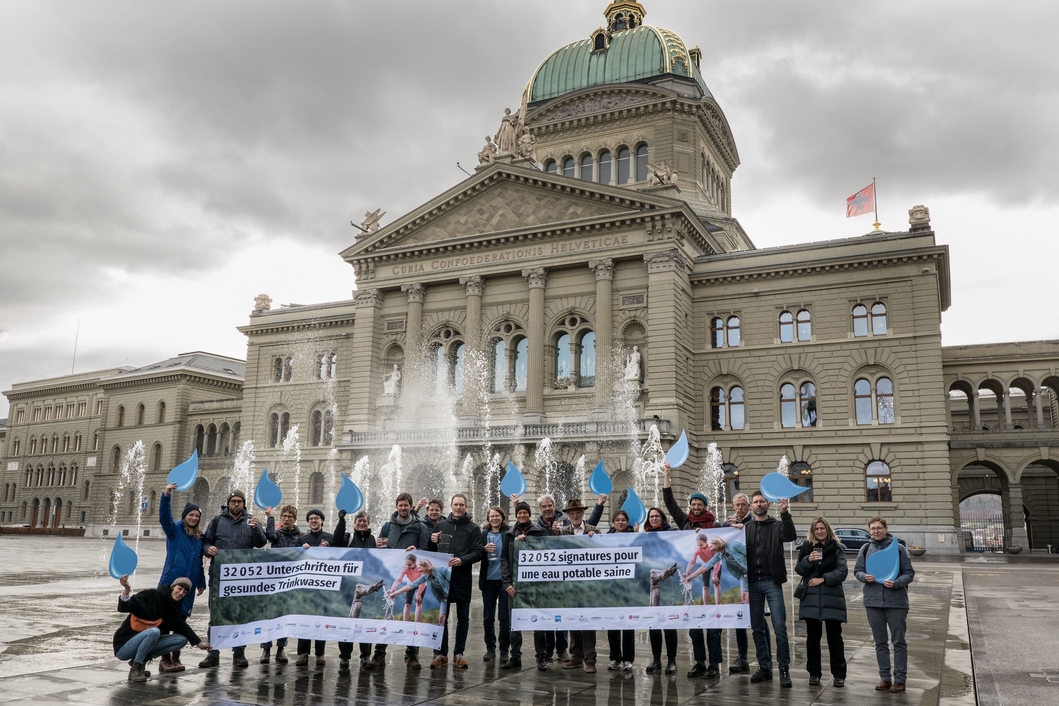 Eine Gruppe Menschen steht mit Bannern vor dem Bundeshaus Bern.