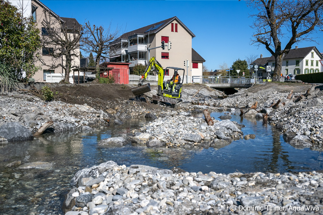 Frisch Revitalisierter Bach ohne Pflanzen an Böschung im Dorf mit Bagger
